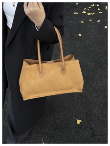 Brown suede tote bag shown on asphalt with ginkgo leaves for a minimal aesthetic view