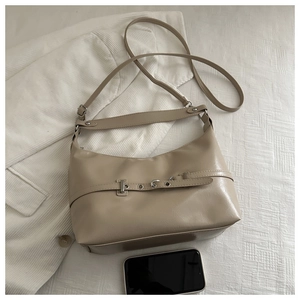 Dettaglio borsa hobo beige con fibbia argento e tracolla regolabile per uso versatile