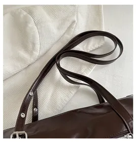 Detail of adjustable dark brown leather strap with silver buckle on a bowling bag