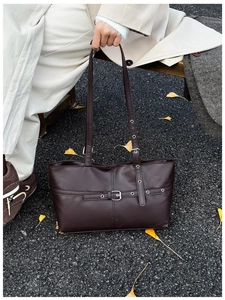 Detail of vintage dark brown tote bag featuring matte leather and adjustable buckle strap