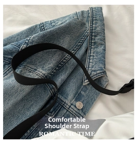 Detail of blue denim fabric texture and wide nylon strap on a casual shoulder bag