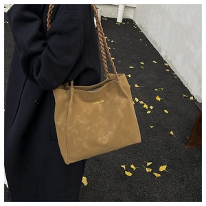 Macro detail of the woven shoulder strap and textured mustard yellow tote bag finish