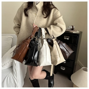 Group display of five minimalist shoulder bags in brown, black, white, and beige tones