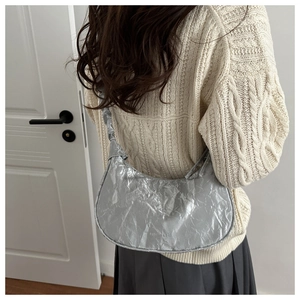 Detail of metallic silver pleated dumpling bag with liquid metal texture and wide strap