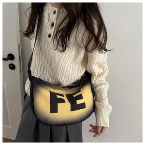 Detail of gradient crossbody crescent bag with FE lettering on a model