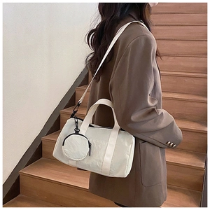 Détail du sac Boston en nylon blanc avec mini porte-monnaie rond sur la bandoulière