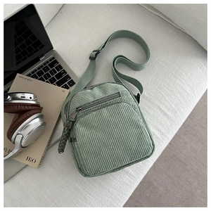 Détail de la sacoche en velours côtelé vert clair avec fermeture tissée et sangle