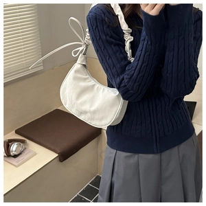 Detail of white half-moon shoulder bag with ruched strap and elegant ribbon bow