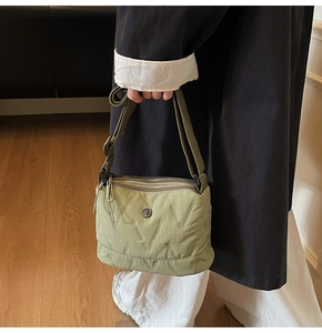 Détail du sac bandoulière en nylon matelassé vert avec trois fermetures à glissière