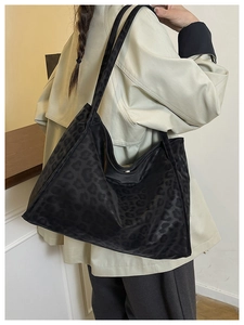 Model view showing the large capacity black leopard print suede tote bag worn on shoulder
