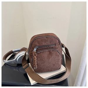 Vue détaillée du sac bandoulière en velours côtelé marron avec double fermeture