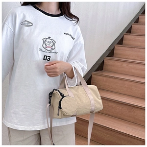 Détail d'un sac bandoulière en toile beige avec sangle réglable et mini pochette