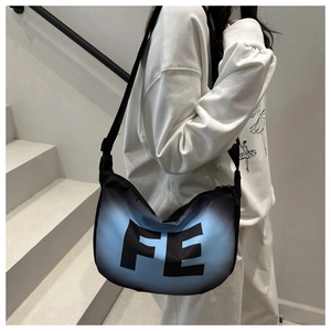 Détail du sac demi-lune dégradé noir et bleu avec impression de lettres FE et sangle