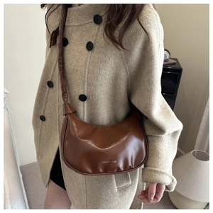 Brown leather hobo bag with Fashion & Bags text shown styled on a beige coat