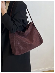 Detail of burgundy leopard print tote bag showing soft suede texture and shoulder straps
