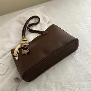 Minimalist deep brown matte leather tote bag with vintage silk scarf on white fabric