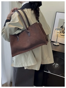 Detailed shoulder view of large dark brown matte suede tote bag in a home setting