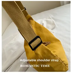 Detail of yellow canvas tote bag featuring an adjustable black strap buckle on white fabric