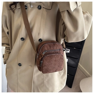 Vue détaillée du petit sac bandoulière en velours côtelé marron avec plusieurs zips