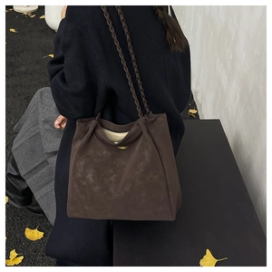 Detail der dunkelbraunen Wildleder-Tote-Bag mit geflochtenen Riemen und Gold-Logo