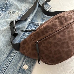 Leopard print suede crossbody bag with dual zippers and adjustable strap on denim