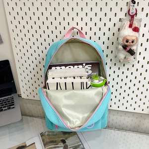 Waterproof blue nylon student backpack with pink zippers showing spacious interior storage