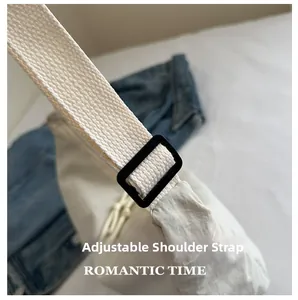 Detail of adjustable woven shoulder strap with black buckle on nylon crescent bag