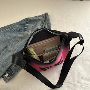 Sac bandoulière dégradé rose et noir pour femme montrant un intérieur spacieux et des objets