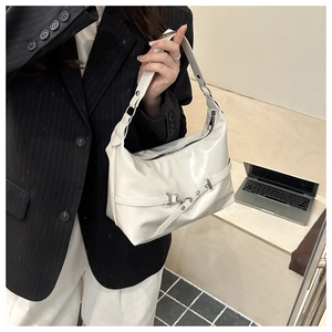Detail shot of the cream white patent leather shoulder bag with decorative buckle and strap