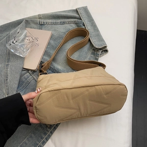 Sac bandoulière matelassé kaki avec large sangle réglable sur fond style de vie