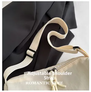 Detail of adjustable woven shoulder strap and zipper on beige crossbody bag