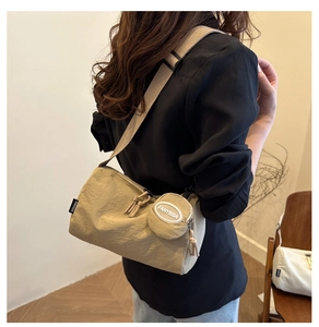 Detail of khaki nylon crossbody bag with adjustable strap and small round coin purse