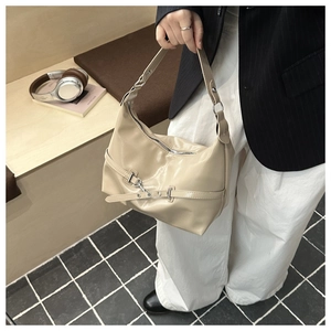 Dettaglio borsa sottobraccio beige minimalista con catena metallica e fibbia in pelle
