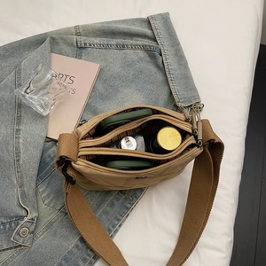Sac bandoulière en nylon oxford matelassé avec plusieurs zips et large sangle