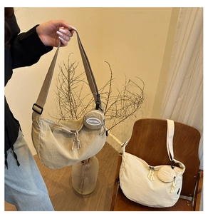 Détail du sac bandoulière demi-lune en nylon avec mini porte-monnaie circulaire amovible