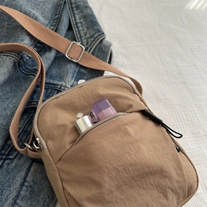 Water-resistant khaki nylon crossbody phone bag with multi-pocket storage and strap