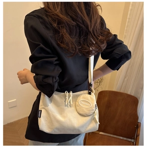 Detail view of cream canvas crossbody bag with adjustable strap and detachable mini coin purse
