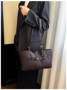 Detailed close-up of dark brown PU leather tote with silver metal buckle and belt accents