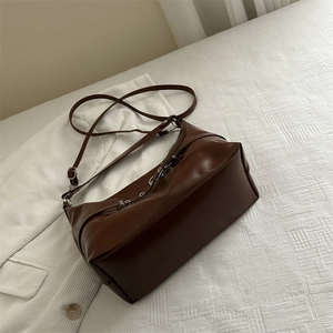 Grande borsa a tracolla marrone in ecopelle su sfondo bianco strutturato ed elegante