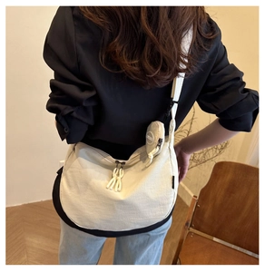 Vue détaillée du sac bandoulière nylon blanc cassé avec petite pochette ronde assortie
