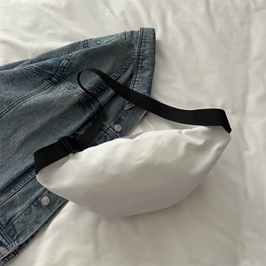 Minimalist white nylon chest bag with adjustable black strap on white bedding backdrop