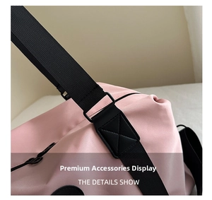Detail of reinforced shoulder strap stitching and buckle on pink waterproof travel bag