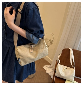 Detail of macaron nylon shoulder bag featuring adjustable strap and knotted zipper puller