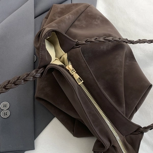 Brown faux suede tote bag with hand-woven handles and a golden zipper closure