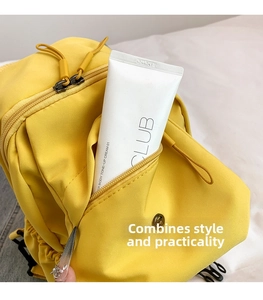 Close-up of a bright yellow nylon chest bag showing multiple functional zipper pockets
