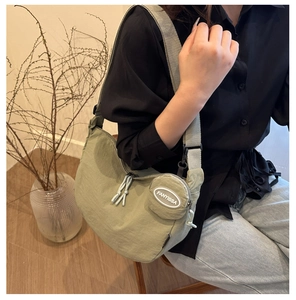 Sage green crescent crossbody bag detail with matching small round coin purse charm