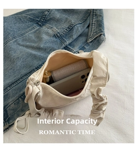 Top view of pleated crossbody bag interior showing phone and lipstick storage space
