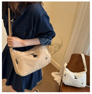 Detail view of khaki and white nylon crossbody bags with drawstrings and textured finish