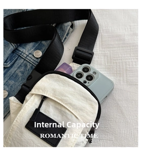 Internal capacity of the white nylon crossbody bag holding a smartphone and lipstick