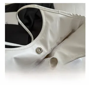 Detail of the high-quality magnetic metal clasp on white lace textured tote bag